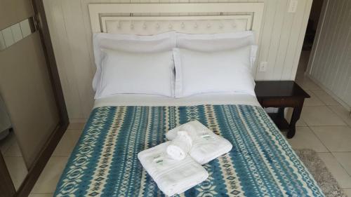 a bed with two towels sitting on top of it at Rosa dos Ventos - CASA in Urubici