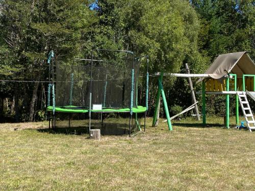 a playground with a swing set and a slide at Cabañas Campestres Villarrica in Villarrica