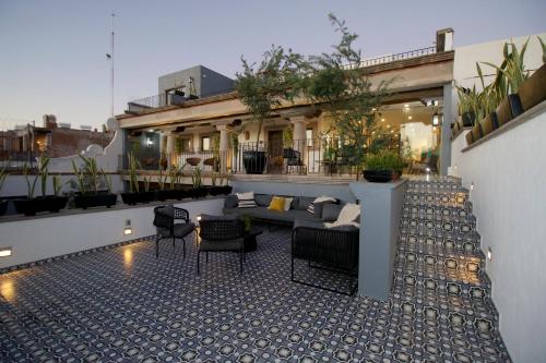 a patio with a couch and chairs on a building at Hotel Boutique Casa Loreta in Querétaro