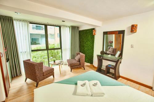 a hotel room with a bed and a table and chairs at Inti Tampu Inn in Cusco