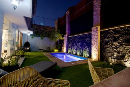 a swimming pool in the middle of a room with chairs at Hotel Boutique Casa Loreta in Querétaro