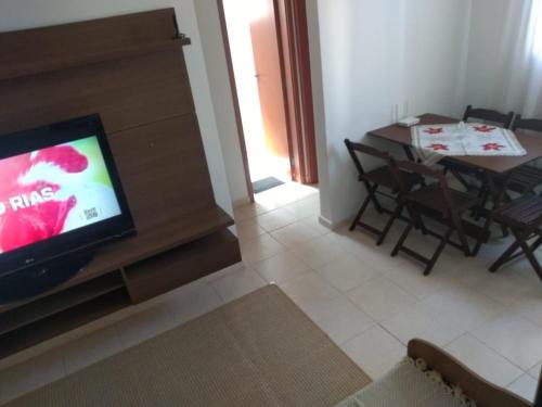 a living room with a television and a table with chairs at Apto se sentindo em casa in Campos dos Goytacazes