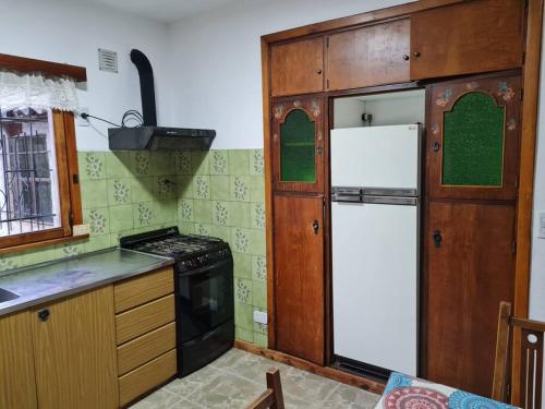 eine Küche mit einem Kühlschrank und einem Herd in der Unterkunft Alpenhaus - Cálido depto céntrico 5 pax - con estacionamiento in San Carlos de Bariloche