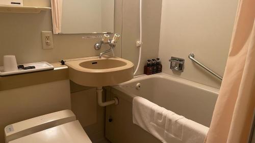 uma casa de banho com um lavatório, um WC e uma banheira em Oita Regal Hotel em Oita