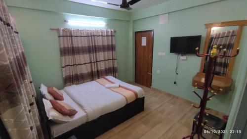 1 dormitorio con 1 cama y TV en Hotel Pokhara Paradise, en Pokhara