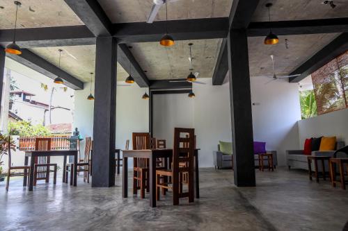a room with tables and chairs and a couch at Atrium Hiriketiya in Hiriketiya