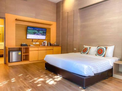a bedroom with a large bed and a flat screen tv at Treescape Resort Chiangmai in Chiang Mai