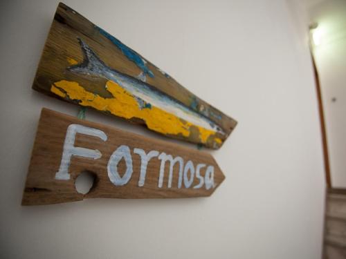 a sign that says fomos hanging on a wall at Formosa Guest House in Tavira