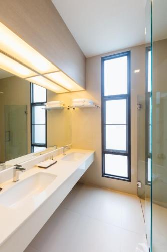 a bathroom with two sinks and a large mirror at Treescape Resort Chiangmai in Chiang Mai