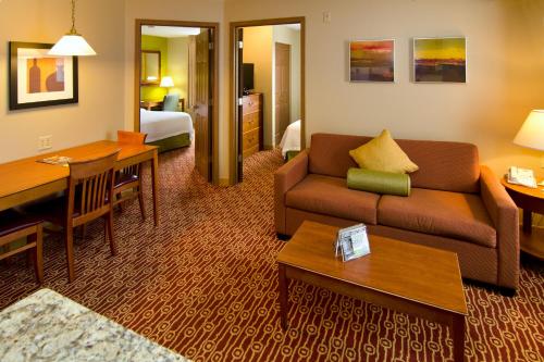 a hotel room with a couch and a dining room at Extended Stay America Suites - St Louis - Fenton in Fenton