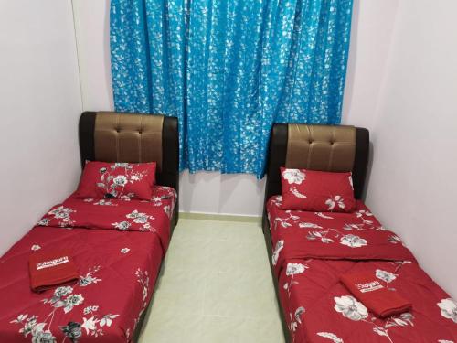 two beds sitting next to each other in a room at TAMU HOMESTAY in Kuala Terengganu