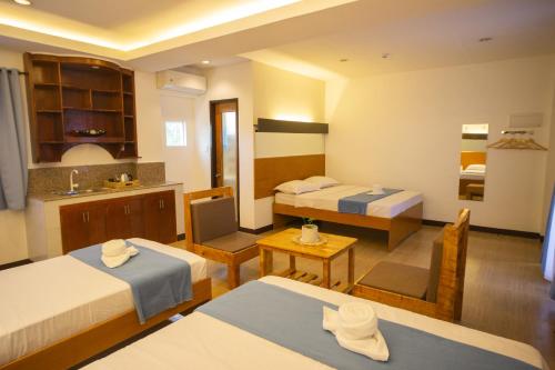 a hotel room with two beds and a kitchen at Siman Panglao in Panglao