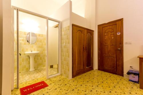 a bathroom with a toilet and a sink and a door at Blossoming Romduol Boutique in Siem Reap