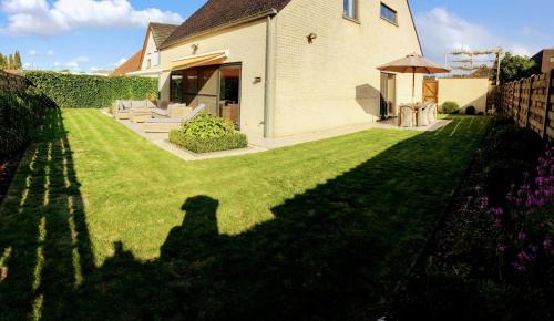 a shadow of a dog on a lawn at Villa Tomasso in Eeklo
