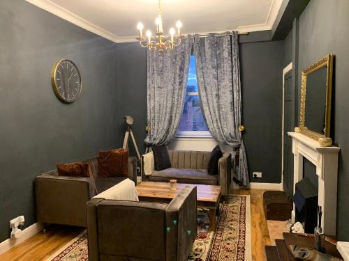 a living room with a couch and a table at Glamours stylish Victorian apartment near city centre in Edinburgh