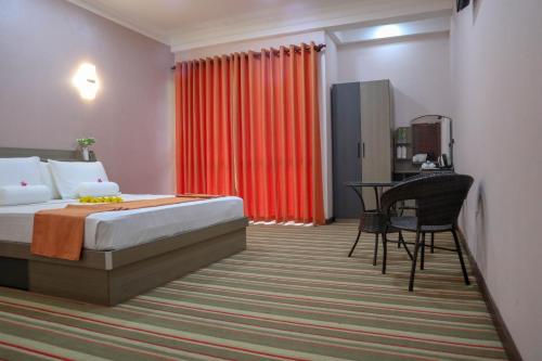 ein Schlafzimmer mit einem Bett und einem Schreibtisch in einem Zimmer in der Unterkunft Reddalf's Holiday Resorts in Arugam Bay