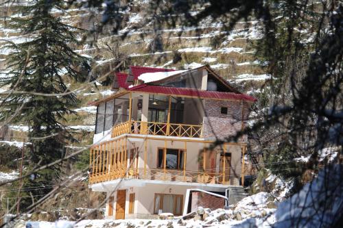 a house on top of a snow covered mountain at ThePahadians Food & Stay in Jibhi