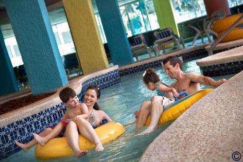 a group of people sitting on inflatables in a swimming pool at Captain's Quarters Resort in Myrtle Beach
