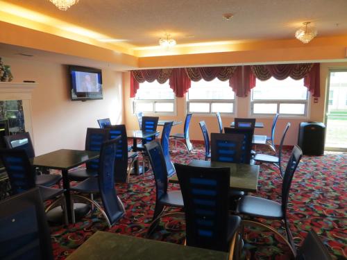 a restaurant with tables and chairs in a room at Crystal Star Inn Edmonton Airport with free shuttle to and from Airport in Leduc