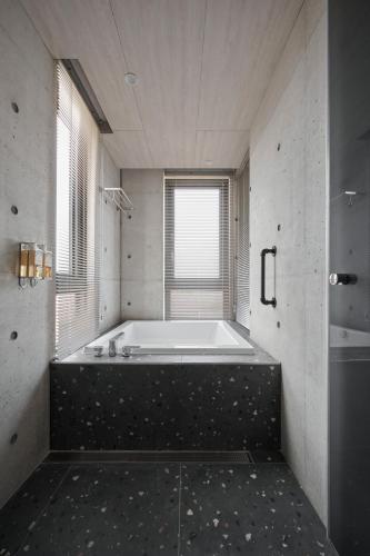 a large bath tub in a bathroom with a window at Penghu Somewhere Guesthouse 澎湖嶼光角落民宿 in Magong