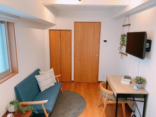 a living room with a blue couch and a table at Dash Living Shinjuku in Tokyo