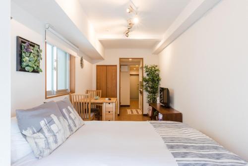 东京Dash Living Shinjuku的一间带床的卧室和一间餐厅