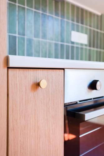 - une cuisine avec une armoire en bois et une cuisinière dans l'établissement Grand T3 - 300m de la mer - CLIM, à La Ciotat