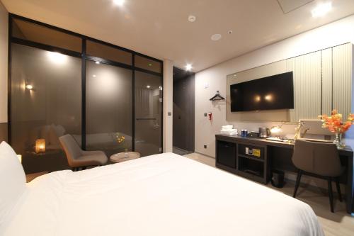 Dormitorio con cama, escritorio y TV en City Hotel the Busan Metro en Busan