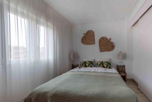 a white bedroom with a bed and a window at Brand new Javea apartment 50m from Arenal beach in Jávea
