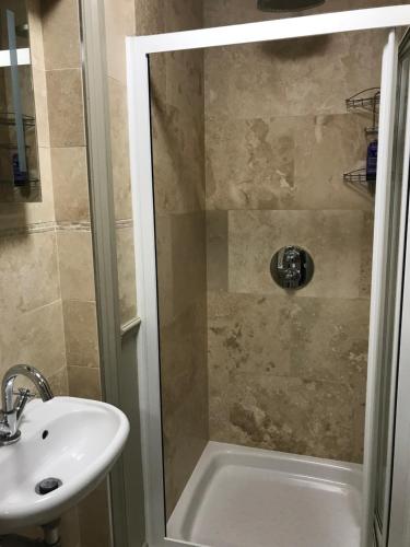 uma casa de banho com um chuveiro e um lavatório. em Highview Bed and Breakfast em Nailsworth