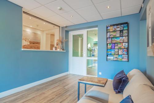 a living room with blue walls and a couch at Hotel De Koningshof in Noordwijk aan Zee