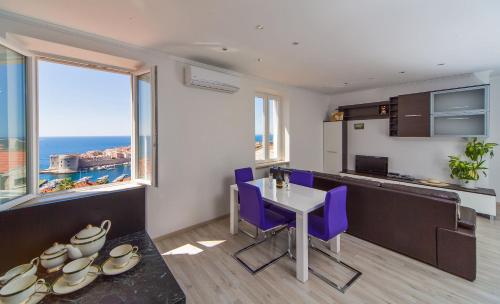 a kitchen with a table and purple chairs in a room at Apartment Astelas in Dubrovnik