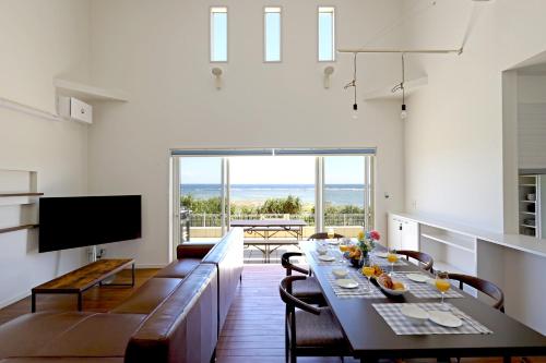 ein Wohnzimmer mit einem Esstisch und einem TV in der Unterkunft オーシャンヴィラ徳之島-Ocean Villa Tokunoshima- in Tokunoshima