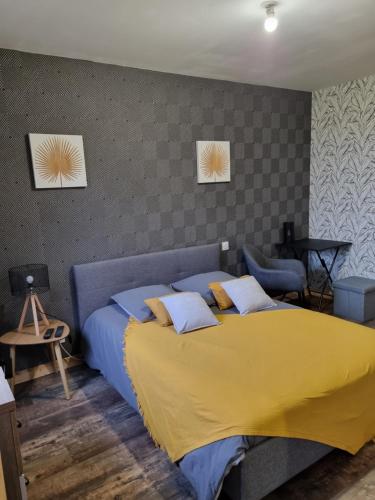 a bedroom with a large bed with a yellow bedspread at Cocon in Plérin