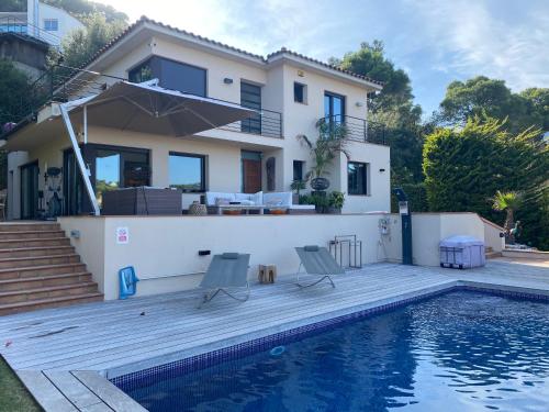a villa with a swimming pool in front of a house at Casa Tanio 150m walking from the village and town of Tamariu in Tamariu