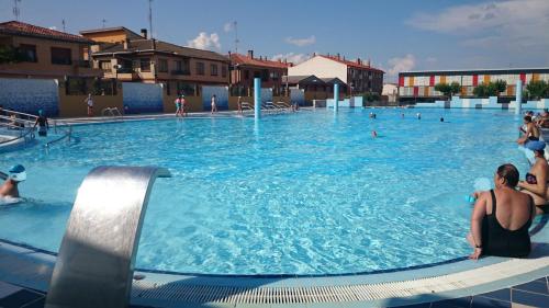 a large swimming pool with people sitting in it at Apartamentos Ribera Navarra - Bardenas in Castejón