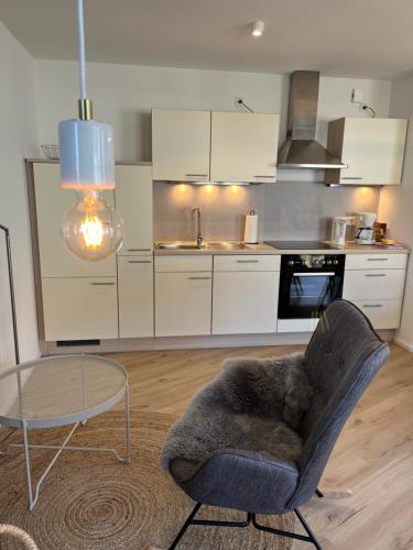 a kitchen with a chair and a table in a room at Moderne Ferienwohnung zum Wohlfühlen in Lindenberg im Allgäu