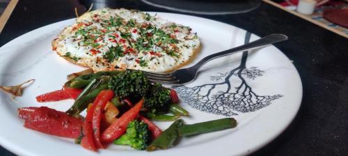 une assiette de denrées alimentaires avec fourchette et légumes dans l'établissement Flipsyde Retreat, à Kasol