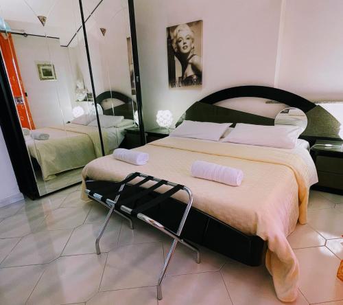 a bedroom with a large bed and a mirror at Villa Ambra B&B in Noto