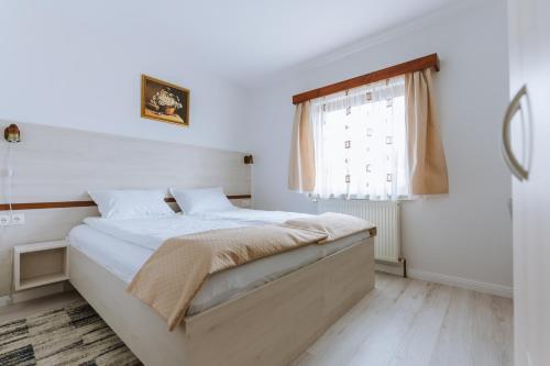 a bedroom with a bed and a window at Juliu's Panzio Csikszereda in Miercurea-Ciuc