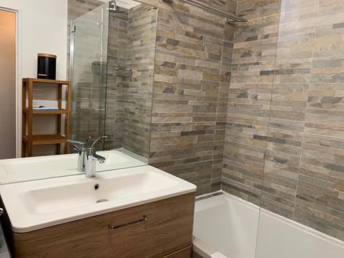 La salle de bains est pourvue d'un lavabo et d'une douche. dans l'établissement Superbe appartement 3 pièces 57 m2 avec Terrasse 33m2, à Levallois-Perret