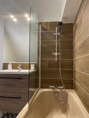 une salle de bain avec une baignoire et un lavabo dans l'établissement Charmant appartement 4 pers au centre des remparts, à Guérande