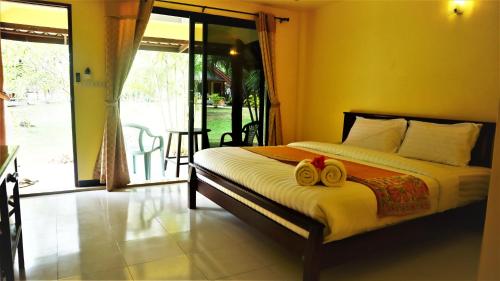 una camera da letto con un letto con due asciugamani sopra di Koh Yao Noi Beach Resort a Ko Yao Noi