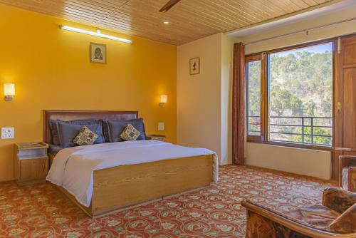 The Green Heights Cottage Kasauli في كاساولى: غرفة نوم بسرير كبير ونافذة كبيرة