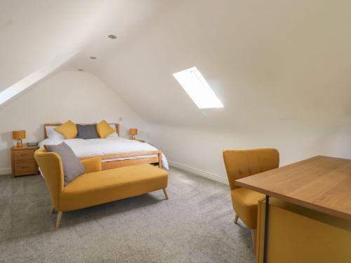 a bedroom with a bed and a table and chairs at Broadford Barn - Barn conversion in picturesque village in Shalford