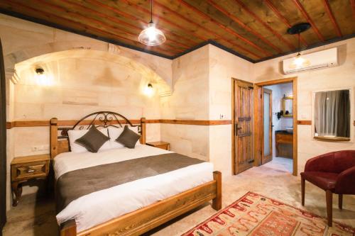 um quarto com uma cama e uma cadeira vermelha em Sapphire Stone hotel em Goreme