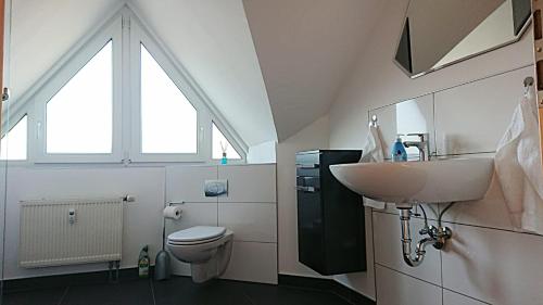 a bathroom with a sink and a toilet and a window at Ferienwohnung Edermündung in Haldorf