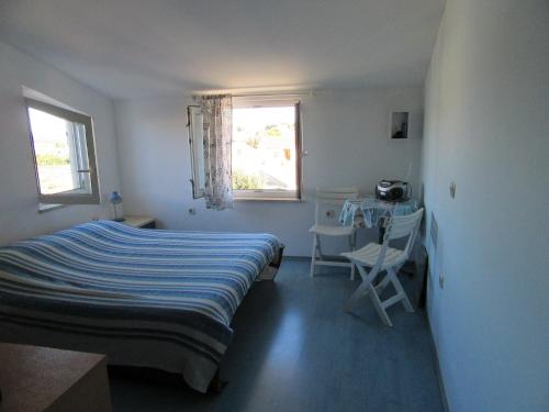 een slaapkamer met een bed, een tafel en een raam bij Apartment Antonio in Pula