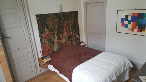 una camera da letto con un letto con arazzo appeso al muro di Charming apartment - Lectoure - gers a Lectoure