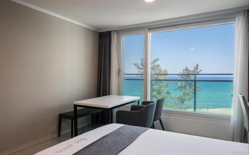 a hotel room with a table and a view of the ocean at Gyeongpo Soo Hotel in Gangneung